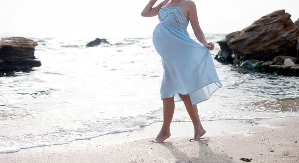 Future mother hiking near sea, pregnant woman belly, no face
