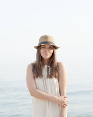 Cute youg calm woman portrait near sea, looking at camera, outdoor