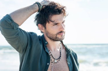 Genç yakışıklı adam okyanus kenarında açık hava portresi