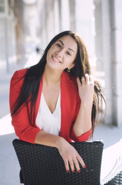 Güzel esmer bir kadın, açık hava portresi, iş kadını kırmızı klasik pantolon giymiş.