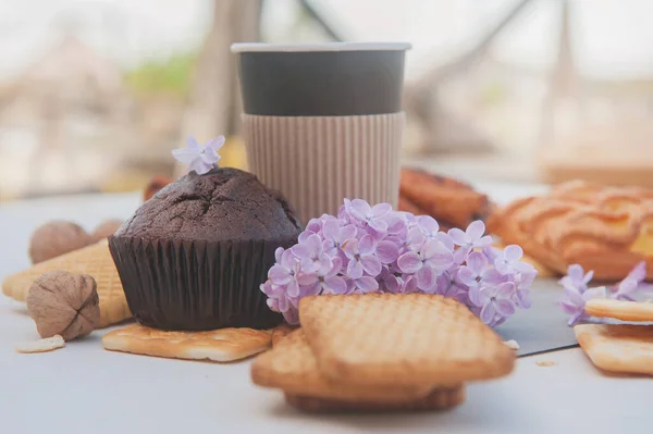 Paper Cup Assorted Pastries Chocolate Muffin Lilac Flowers — Stock Photo, Image