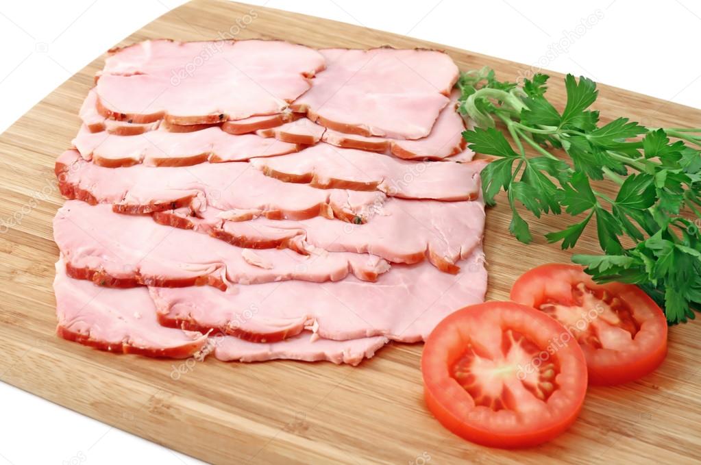 Smoked slices of ham on wooden cutting board