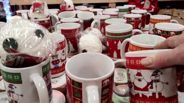 圣诞假期销售和购物 商店里的女店员正拿着圣诞彩绘的红绿杯子指手画脚 — 图库视频影像