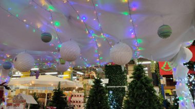 Noel süsleri asmak alışveriş merkezinin lobisini dekore etmek. Büyük bir alışveriş merkezindeki salonun Noel süslemeleri..