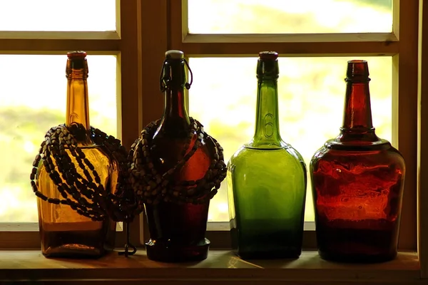 Botellas de vidrio en alféizar de la ventana — Foto de Stock