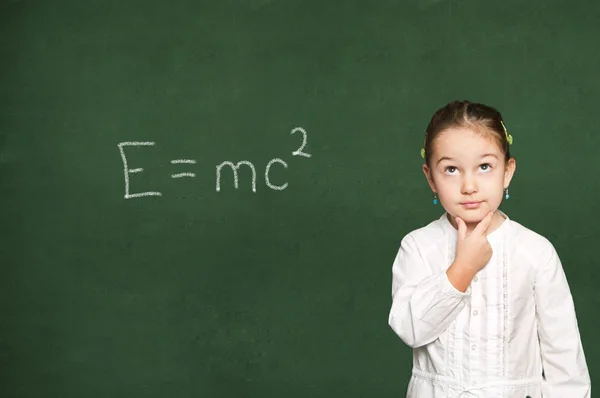 Slim meisje denken, schoolbord achtergrond — Stockfoto