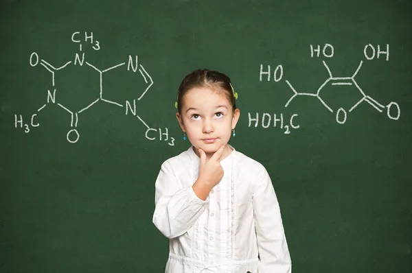 Slim meisje denken, schoolbord achtergrond — Stockfoto