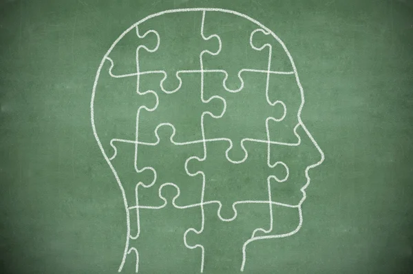 Puzzle in head on chalkboard — Stock Photo, Image