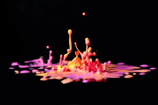 Colorful paint splashing on black. — Stock Photo, Image