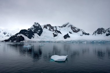 Beautiful reflections over a grey frozen landscape, Antarctica clipart