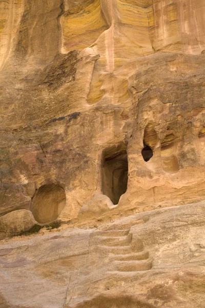 Grotten in de rotswanden die werden gebruikt als huizen voor de bedoeïenen rondom petra, jordan. — Stockfoto