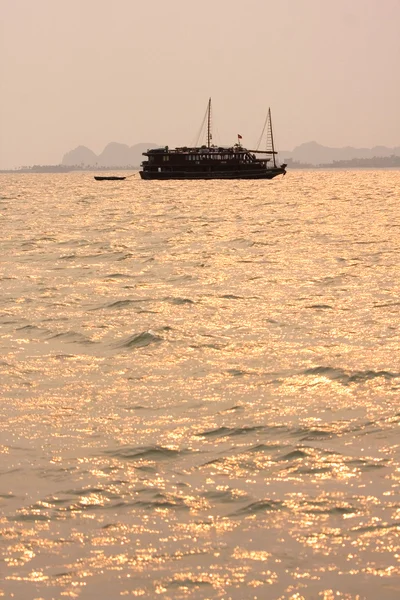 Traditionella vietnamesiska träbåtar segla i halong bay på solnedgången, vietnam, sydöstra Asien. — Stockfoto