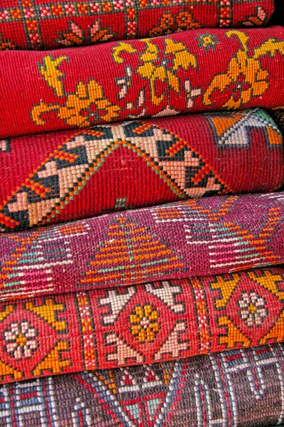 Pile of north african rugs in red, orange & brown shades, Morocc — Stock Photo, Image