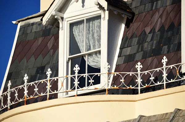 Чердачное окно с кружевным занавесом — стоковое фото