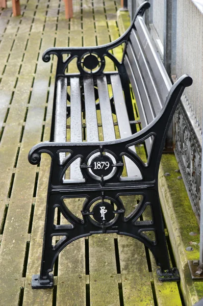 Public wrought iron bench with date — Stock Photo, Image