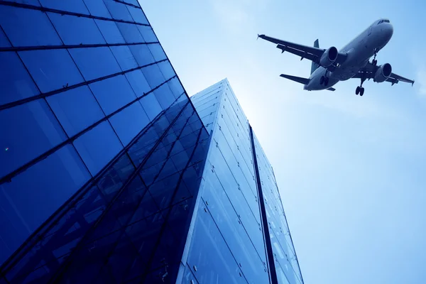 Modern building glass wall. Aircraft in the sky — Stock Photo, Image