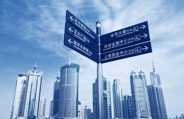 signpost with shanghai skyline of the lujiazui financial center