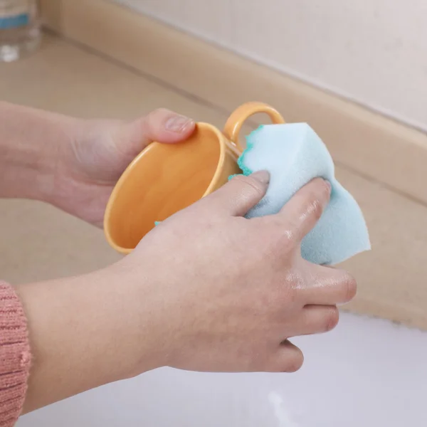 Mano con una esponja tazas de limpieza — Foto de Stock