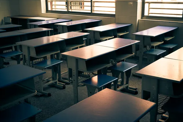 Leeg klaslokaal met stoelen, bureaus en schoolbord. — Stockfoto