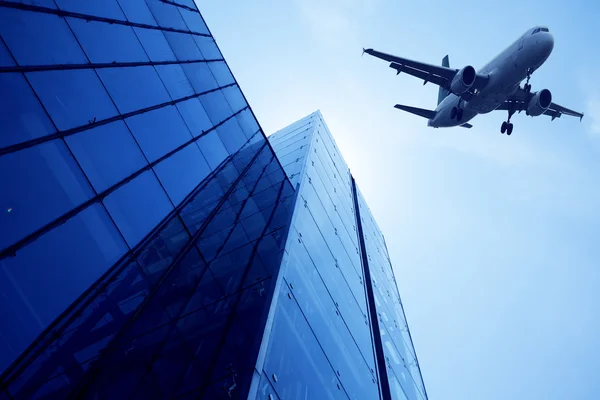 现代建筑玻璃墙。飞机在天空中 — 图库照片