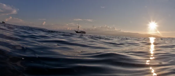 Voilier au-dessus de la mer au coucher du soleil . — Photo