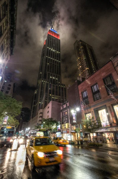 Empire state building en snel bewegende taxi — Stockfoto