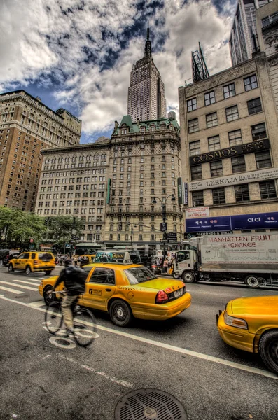 Fietser door het empire state building in new york, Verenigde Staten — Stockfoto