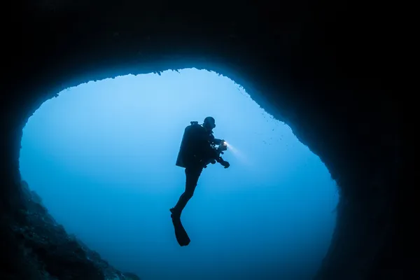 Cave dykare i siluett Stockfoto