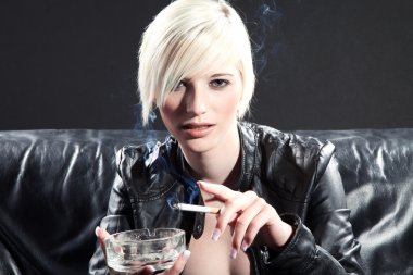 bir sigara siyah bir kanepede sarışın kız