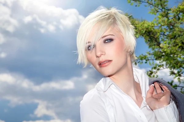 Businesswoman on a background of clouds in the sky — Stock Photo, Image