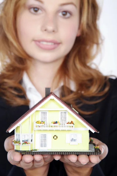 Empresária com uma casa de brinquedo — Fotografia de Stock