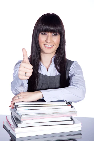 The teacher sits at a table with books and showing ok — Stock Photo, Image