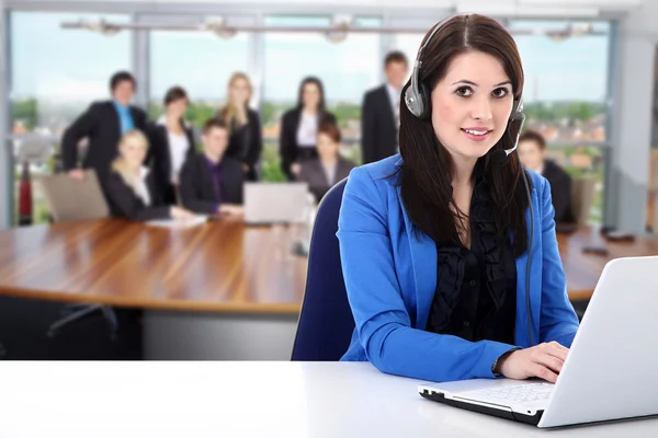 Businesswoman with headphones working on a laptop — Stock Photo, Image