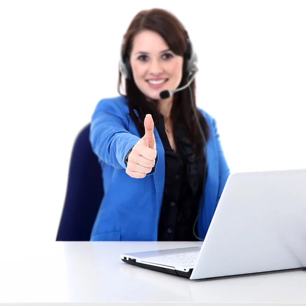 Businesswoman with headphones working on a laptop and showing OK sign — Stock Photo, Image