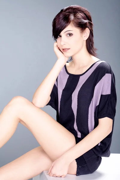 Brunette girl on a white podium — Stock Photo, Image