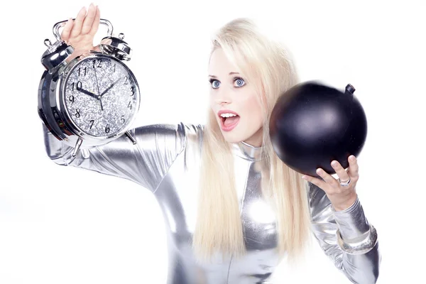 Blonde in a silver dress with an alarm clock and a bomb — Stock Photo, Image