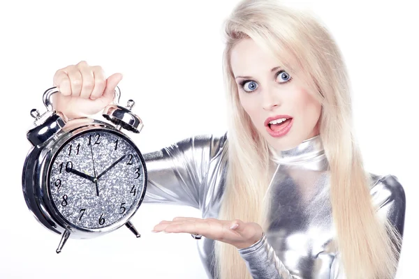 Blonde girl in a silver dress with an alarm clock — Stock Photo, Image