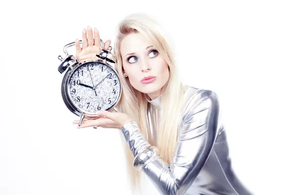 Chica rubia en un vestido de plata con un reloj despertador — Foto de Stock