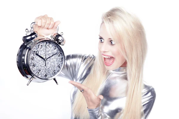 Blonde girl in a silver dress with an alarm clock — Stock Photo, Image