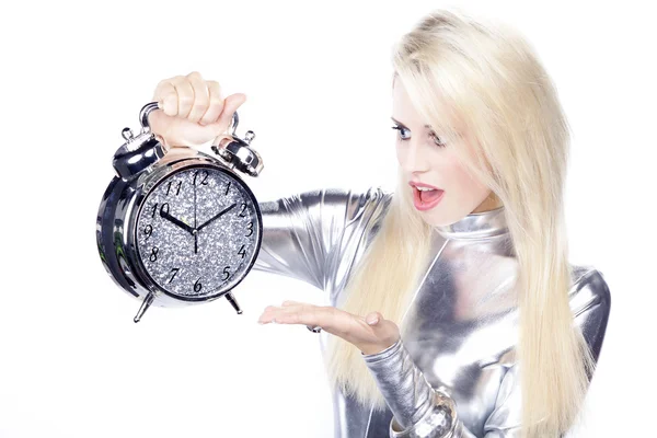 Chica rubia en un vestido de plata con un reloj despertador — Foto de Stock