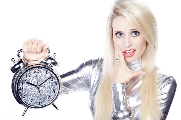 Blonde girl in a silver dress with an alarm clock — Stock Photo, Image