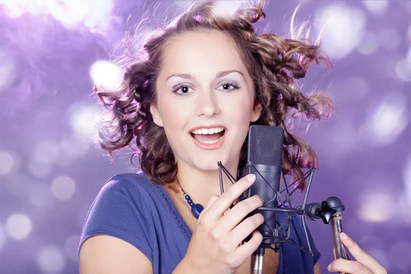 Mädchen singt in ein Mikrofon — Stockfoto