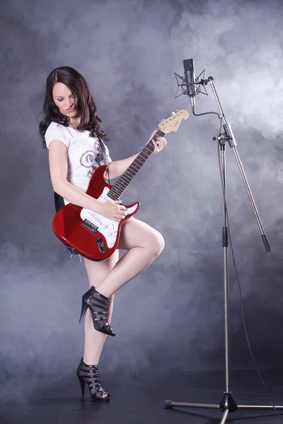 Brunette fille avec une guitare électrique — Photo