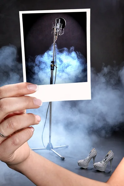 Une fille tient un microphone de studio photo sur le fond de la fumée — Photo