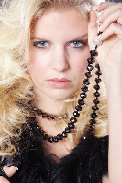 Blonde girl with a necklace in black fur — Stock Photo, Image