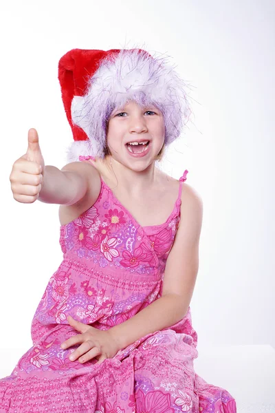 A young girl in a Christmas hat showing sign — Stock Photo, Image