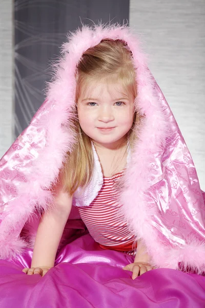 Klein meisje liggen onder een roze deken — Stockfoto
