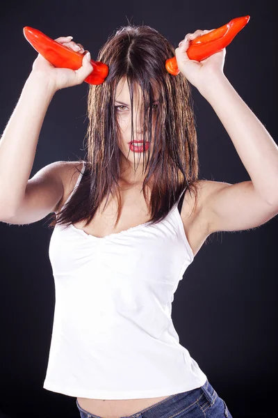 Brunette girl with red peppers — Stock Photo, Image