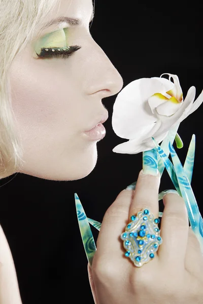 Gezicht blond meisje met witte orchidee — Stockfoto