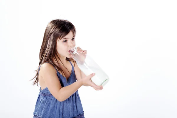 Little girl drinking milk in a plastic bottle — Stock Photo, Image